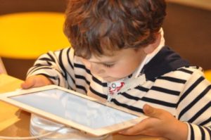 Young boy looking at iPad or tablet