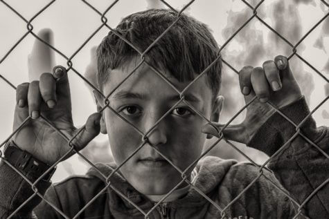 Disadvantaged child behind fence