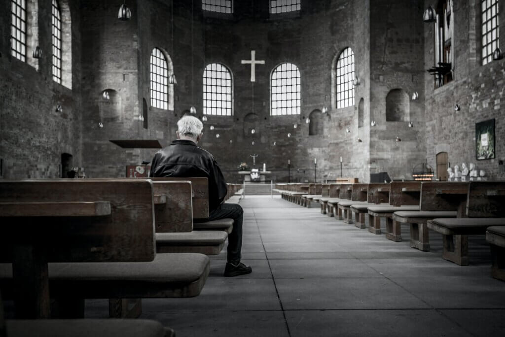 Older man praying in church