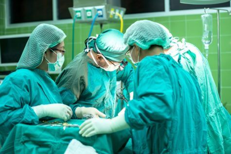 Doctors, nurses performing surgery in operating room
