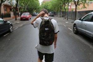 Teen with backpack walking in street