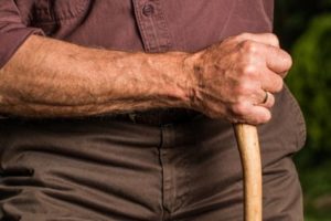 Older man holding cane or walking stick