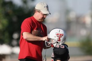 Coach with youth football player