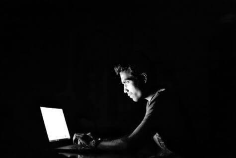 Man looking at computer screen in darkness
