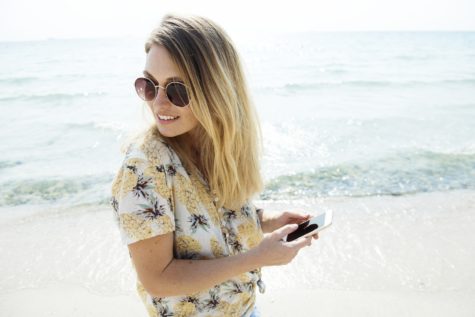 Woman looking at her smartphone at the beach
