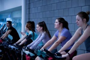 Women on exercise bikes at gym