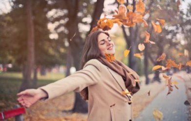 Happy woman throwing leaves