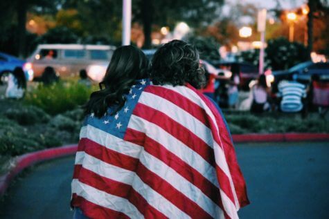 Couple sitting wrapped in US flag