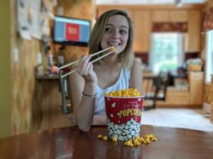 Woman eating popcorn with chopsticks