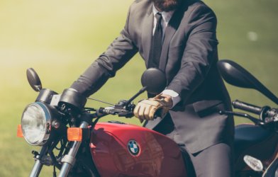 Man in suit riding BMW motorcycle