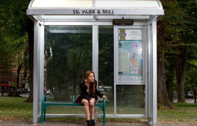 Woman sitting at bus stop