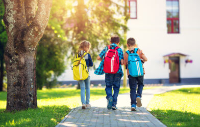 Children walking to school with backpacks on