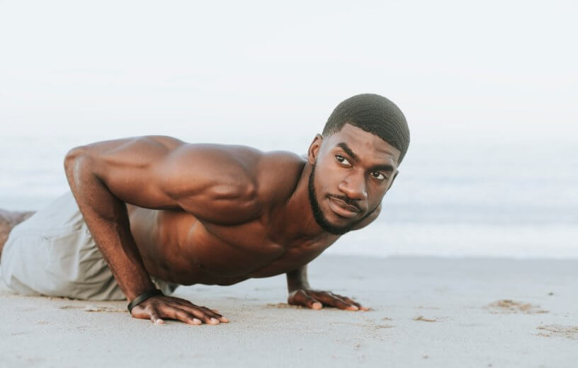 Man doing push-ups on beach