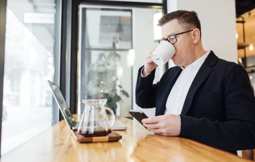 Man drinking coffee while doing work
