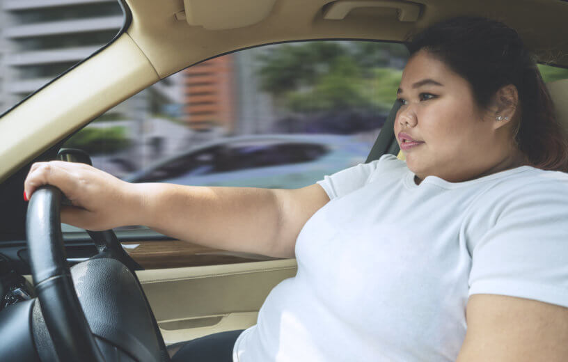 Obesity: Overweight or obese woman driving car