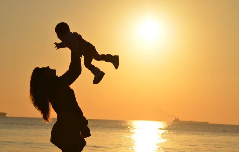 Mother with baby in sunset