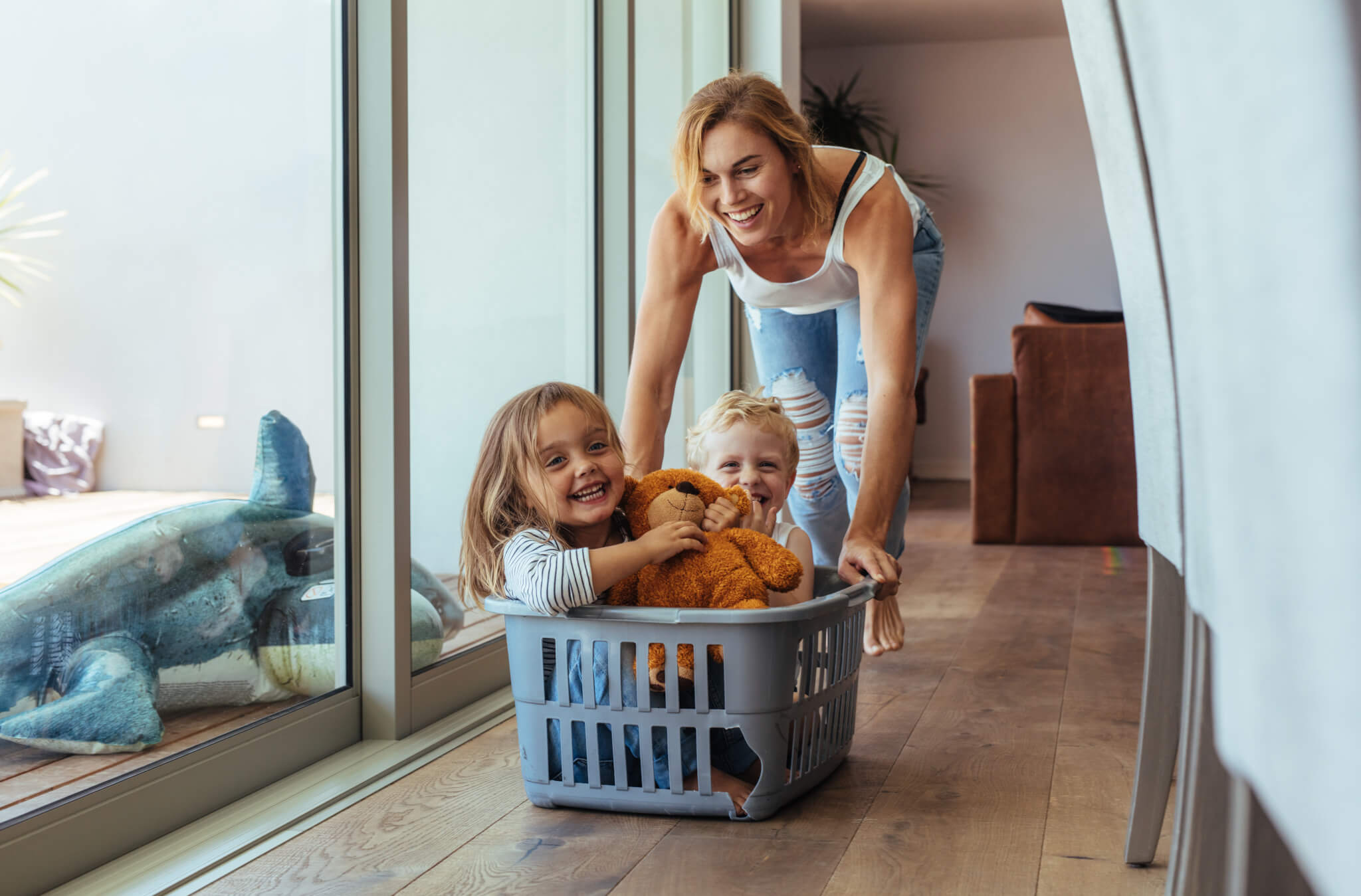 Mother playing with her children in laundry basket