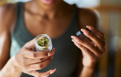 Woman opening jar of medical marijuana