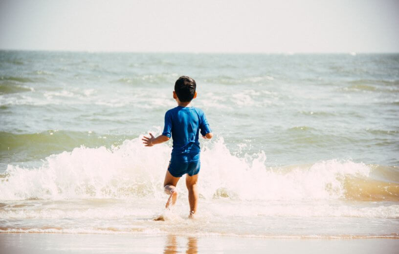 Boy swimming in ocean at beach