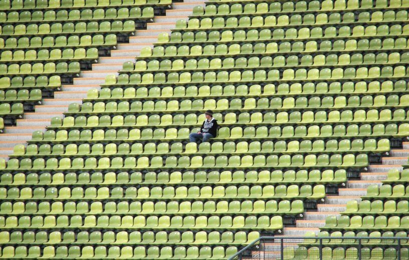 Person sitting alone in college football stadium