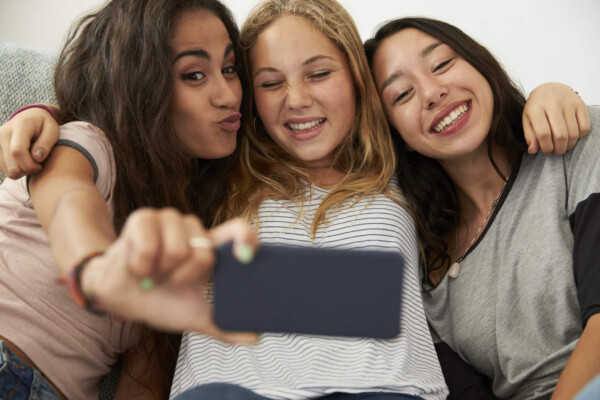 Three teen girls taking selfie at home