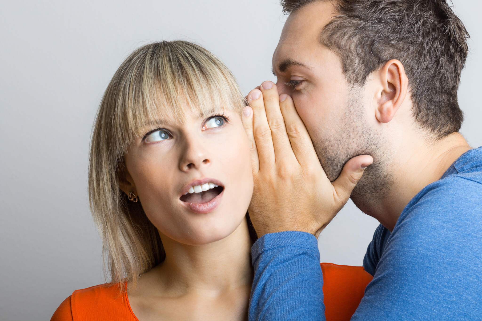 Man telling a woman a secret