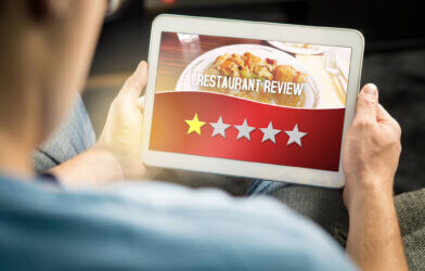 Bad restaurant review. Disappointed and dissatisfied customer giving terrible rating with tablet on an imaginary criticism site, application or website. Man giving one out of five stars at home.