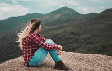 Woman sitting alone on a mountain