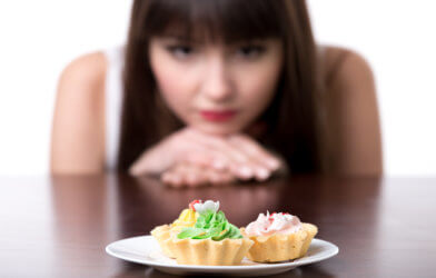 Self-control: Woman resisting temptation to eat cake