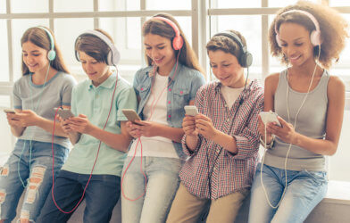Teens, children using smartphones listening to music