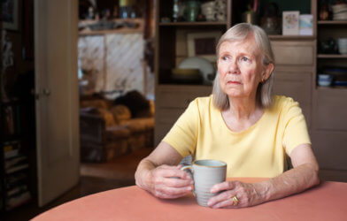 Sad, older woman sitting at table