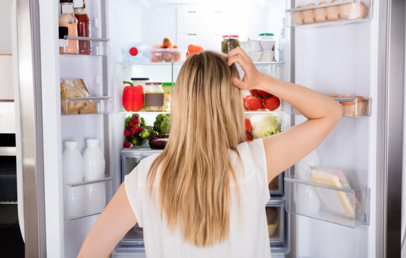 Woman looking at the food in her refirigerator