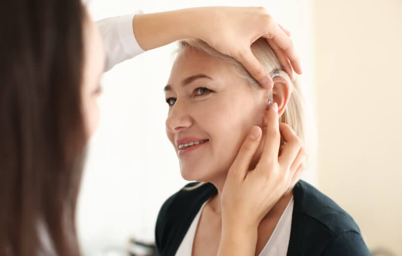 Hearing aid being put in woman's ear