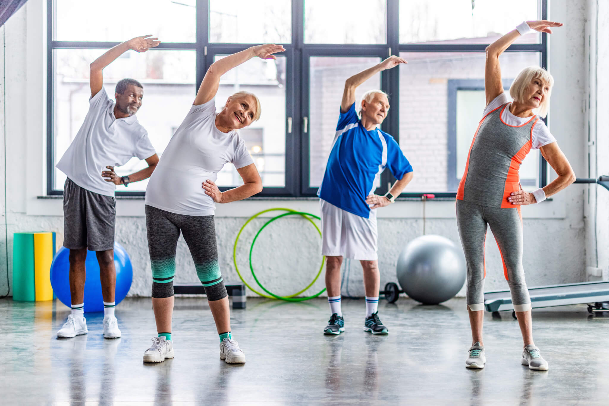 Seniors, older adults enjoying exercise class at gym