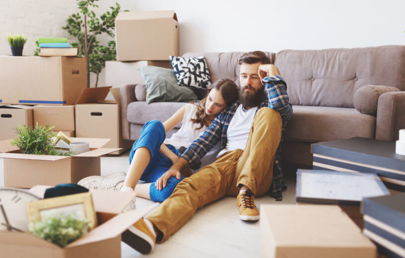 Tired, stressed couple packing boxes while moving