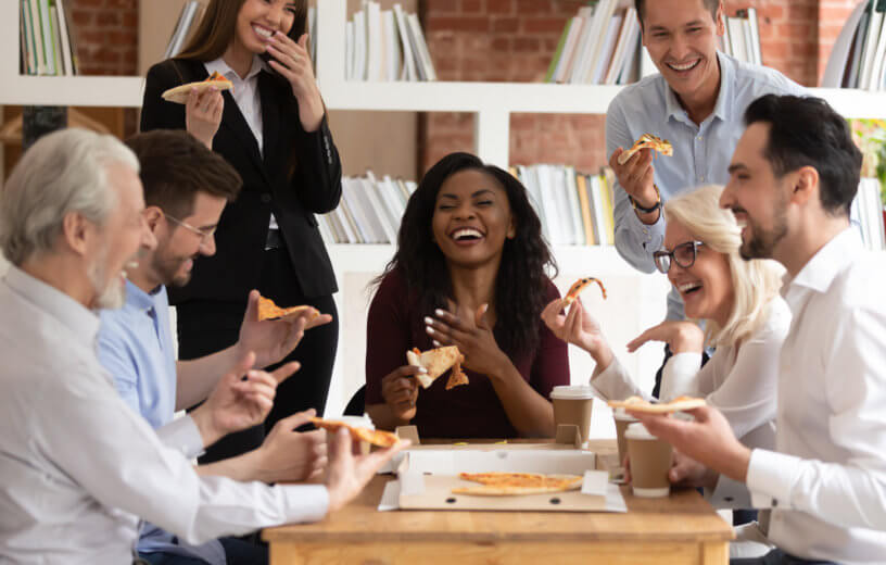 Office workers enjoying pizza lunch meeting with their boss