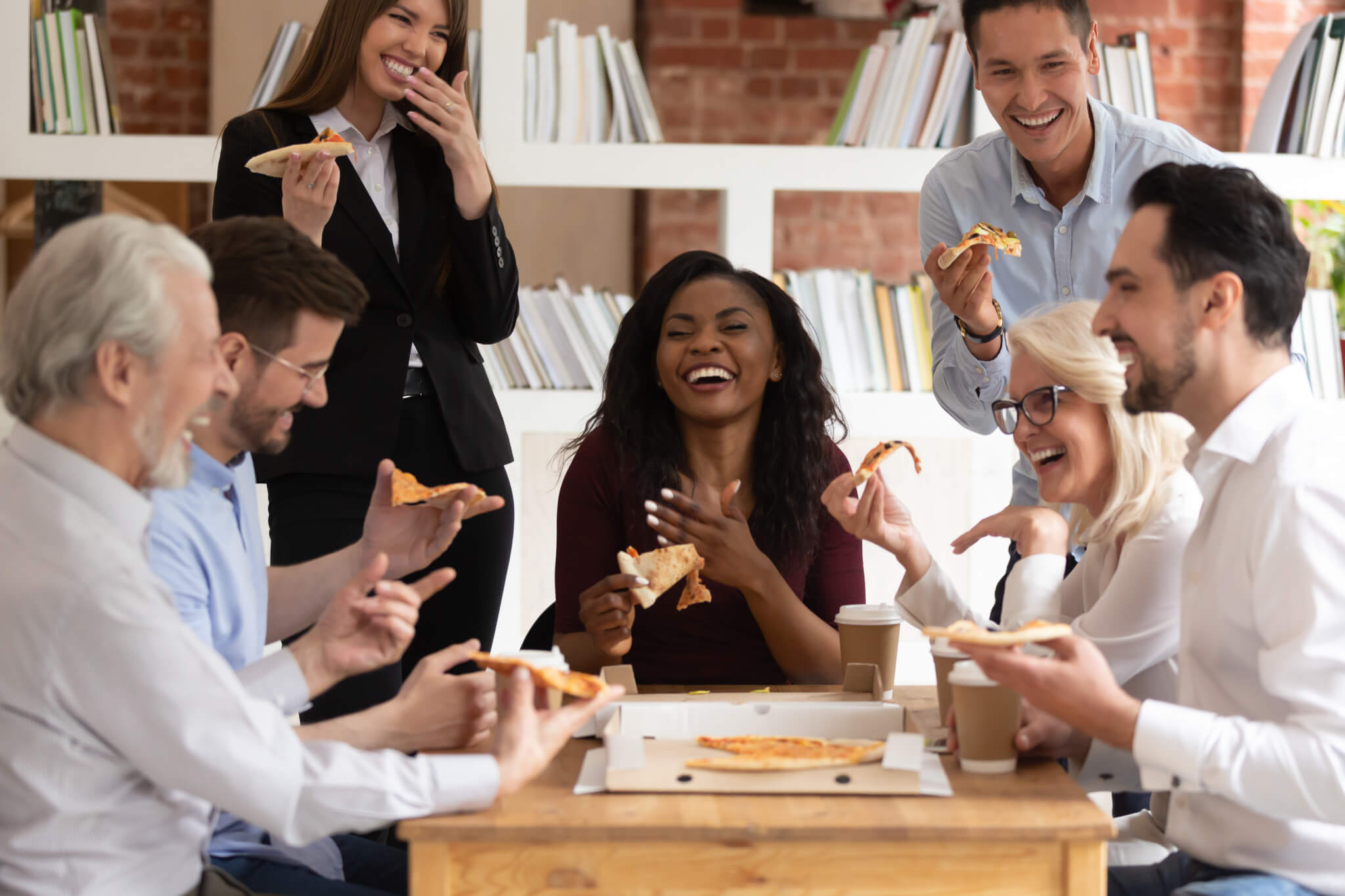 Office workers enjoying pizza lunch meeting with their boss