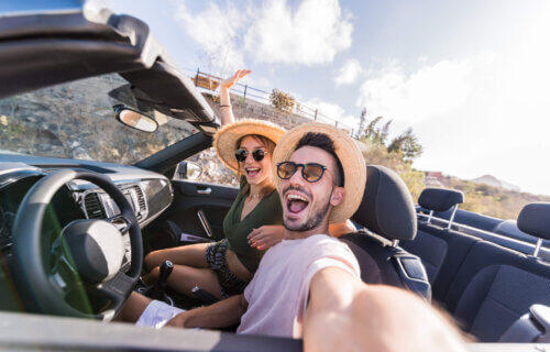 Young couple snapping selfie while driving