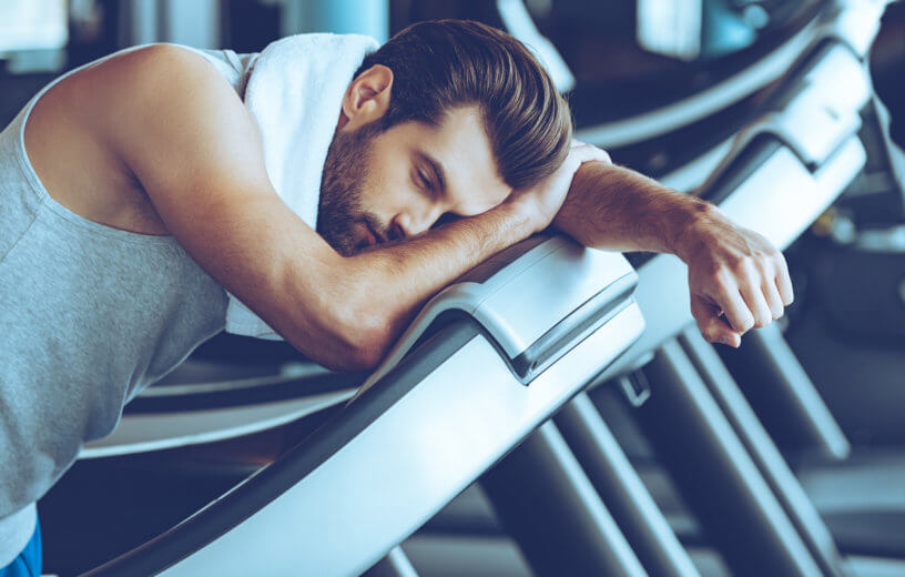 Man on treadmill at gym too tired to run