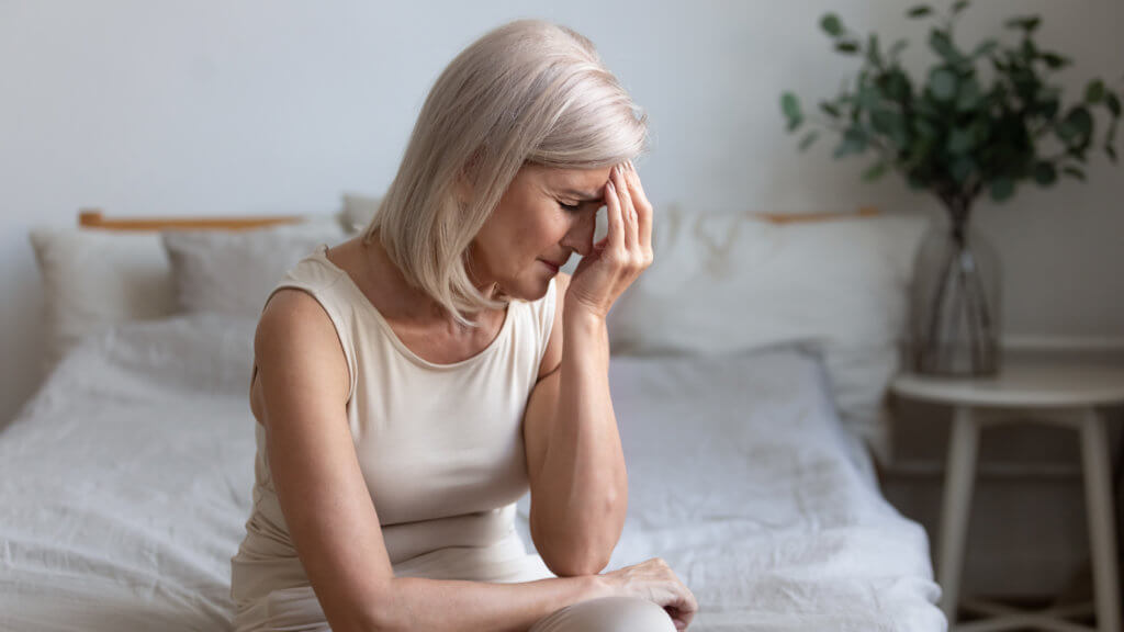 Oudere vrouw gestrest, mogelijk door de menopauze