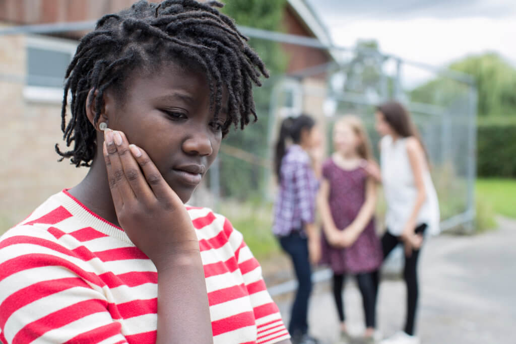 Sad black teen facing bullying, teasing, or racism by peers
