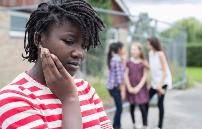 Sad black teen facing bullying, teasing, or racism by peers