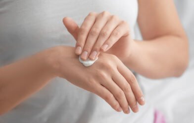 Woman applying hand cream, moisturizer on skin