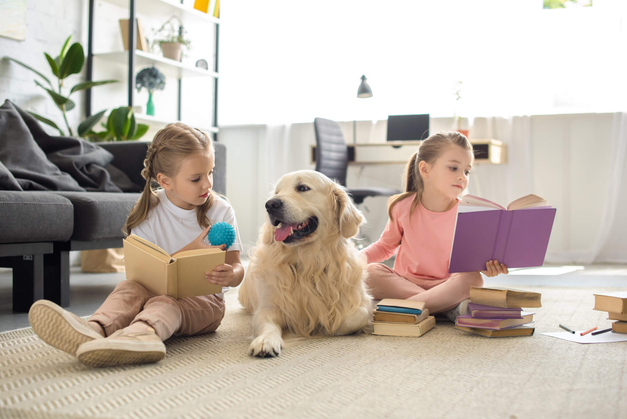 Children reading books to dog