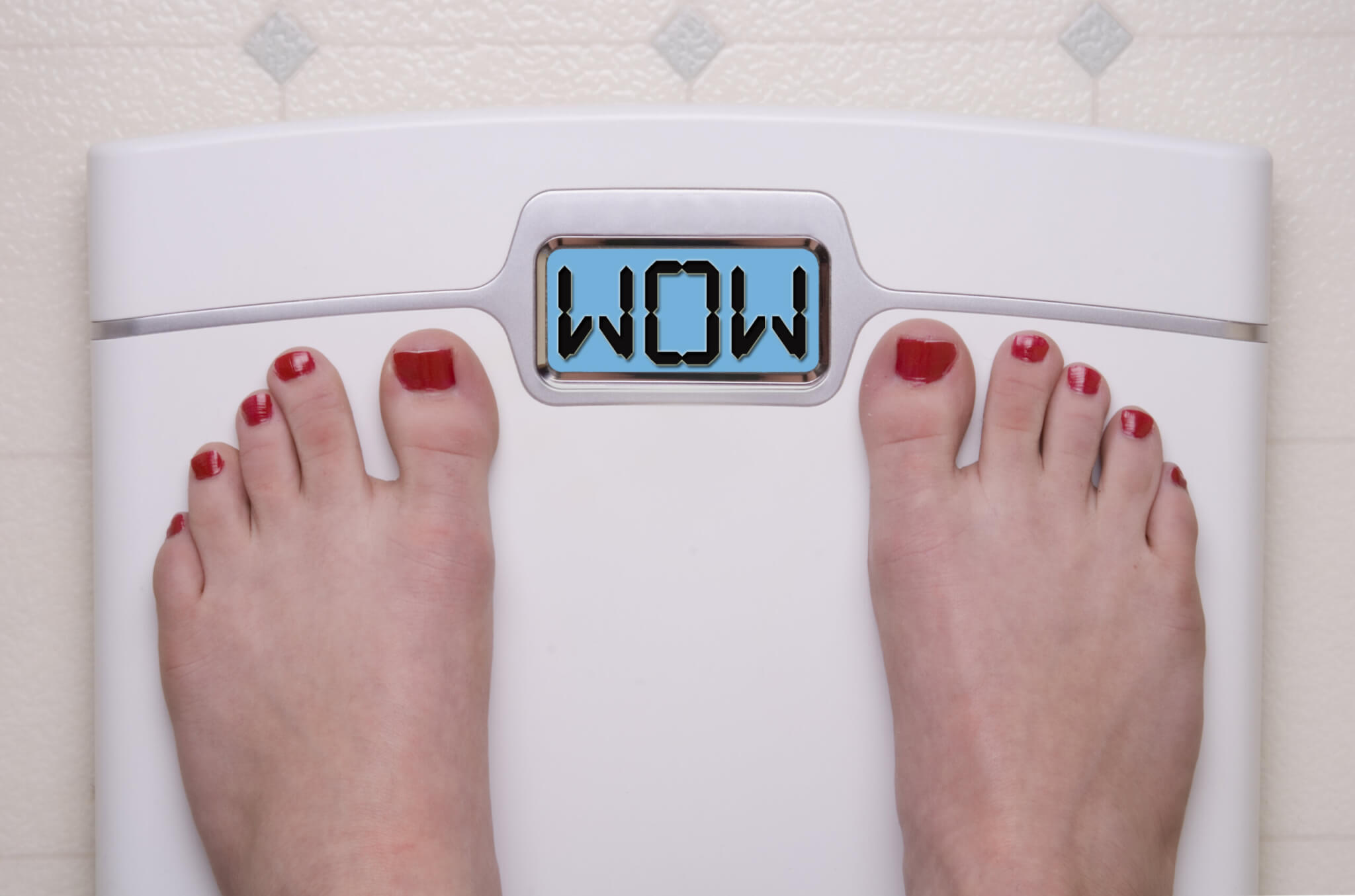 Woman weighing herself on scale that says "WOW"