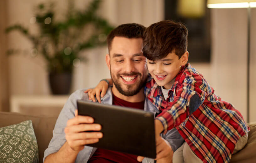 Dad getting help on iPad from young son