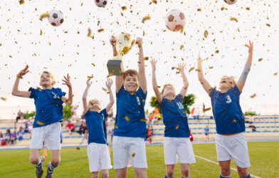 Youth soccer team celebrating with trophy