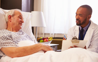Doctor talking to patient in hospital bed