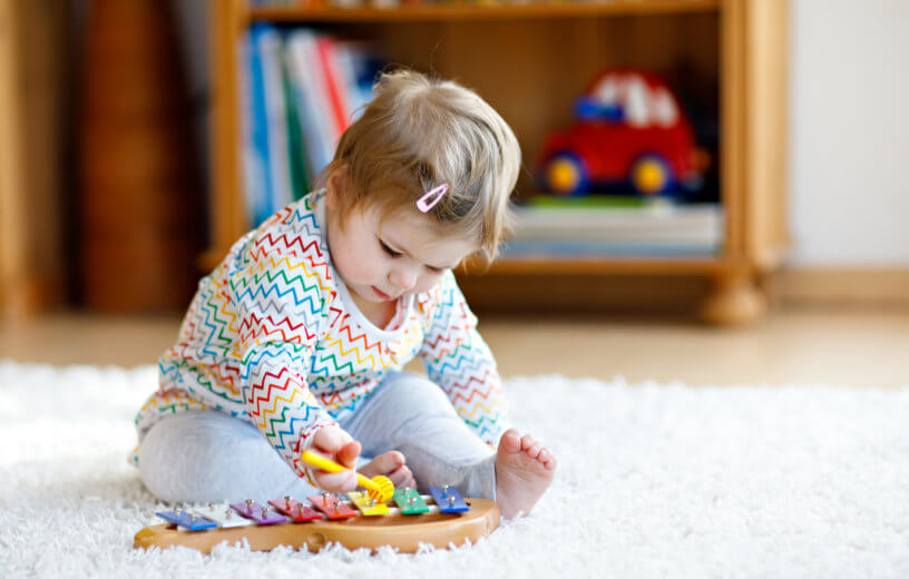 Baby girl or toddler playing xylophone
