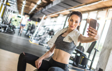 Woman taking selfie while exercising at the gym